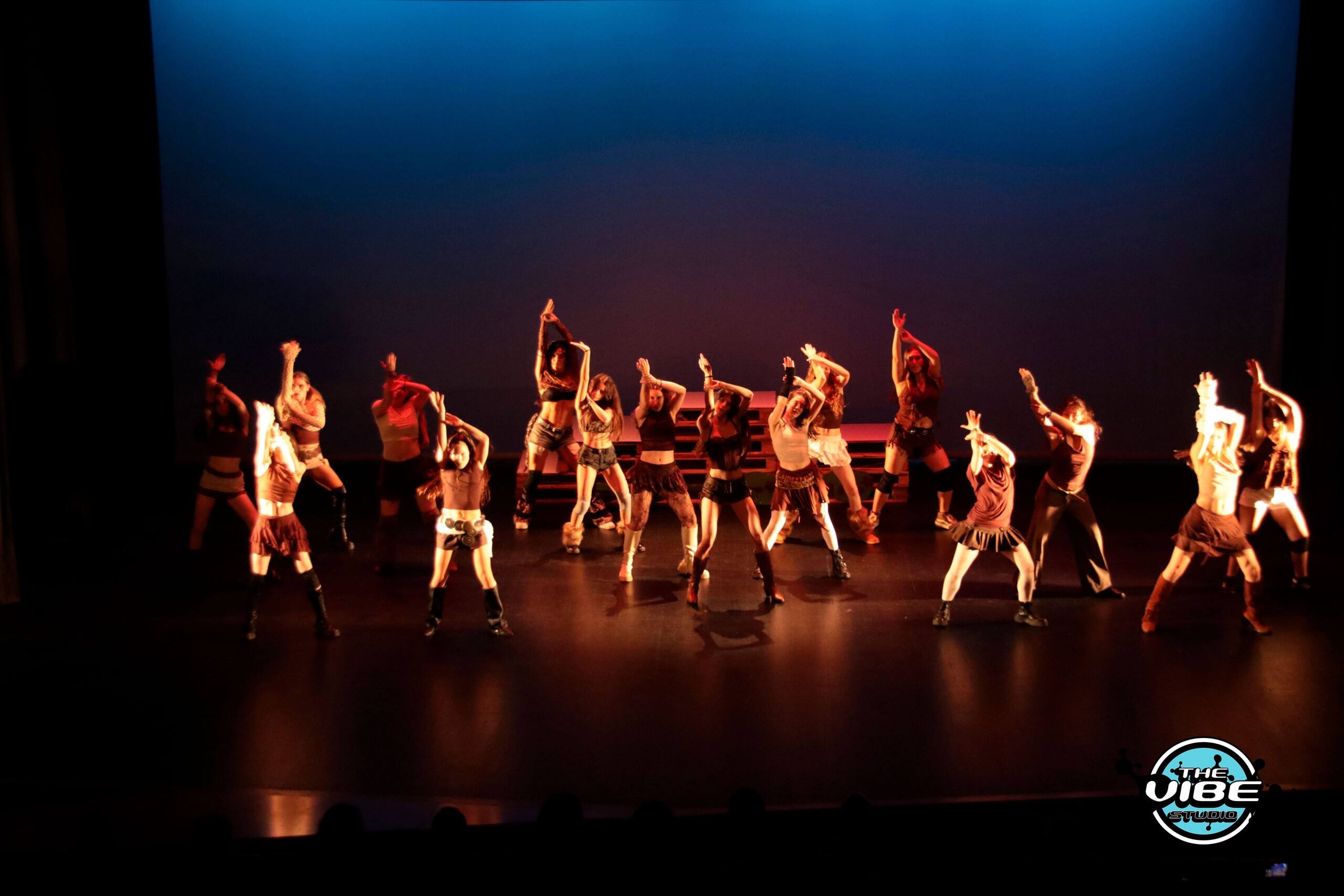 Alumnado de The Vibe Studio actuando en un escenario con luz azul