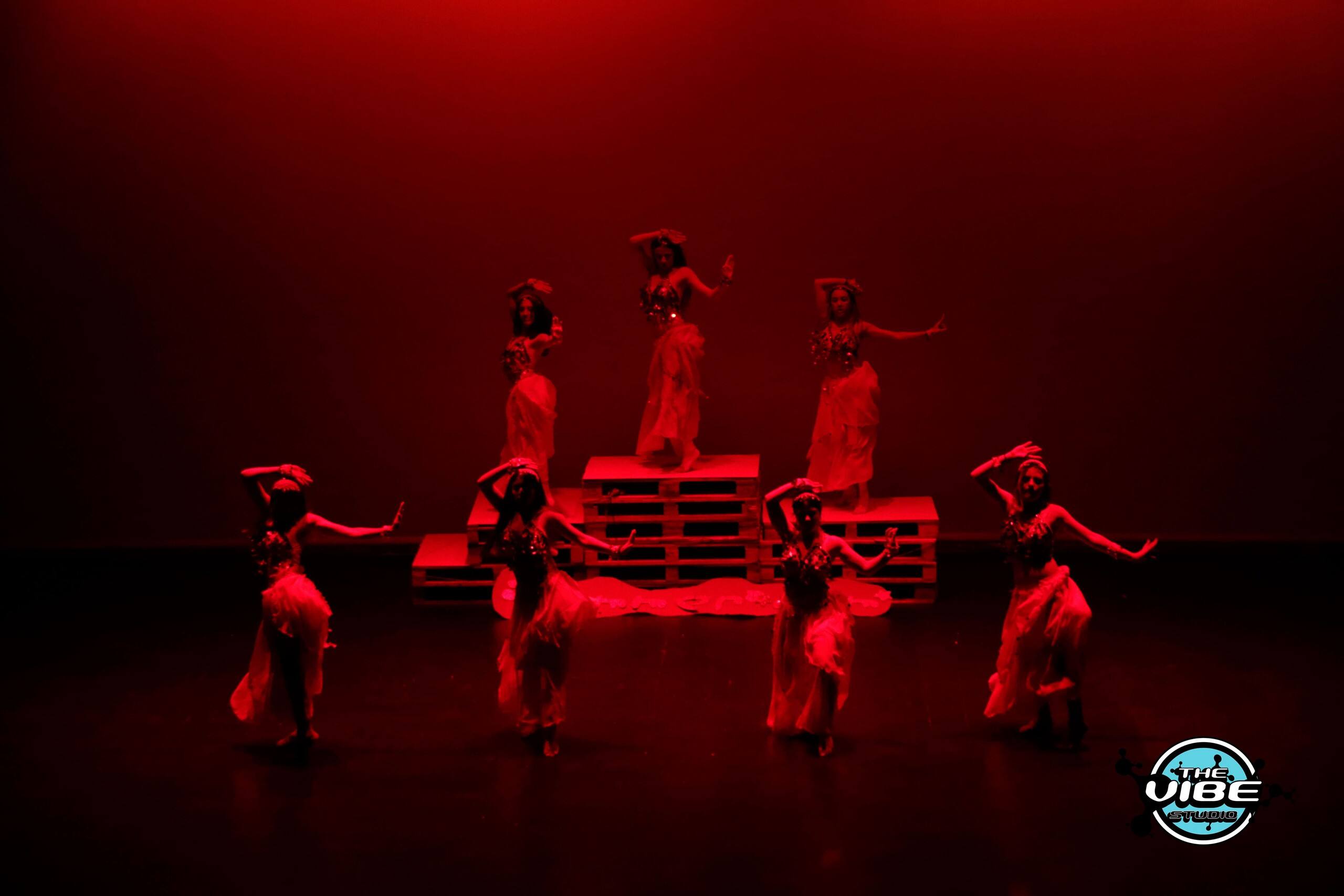 Coreografía de The Vibe sobre el escenario con luz roja