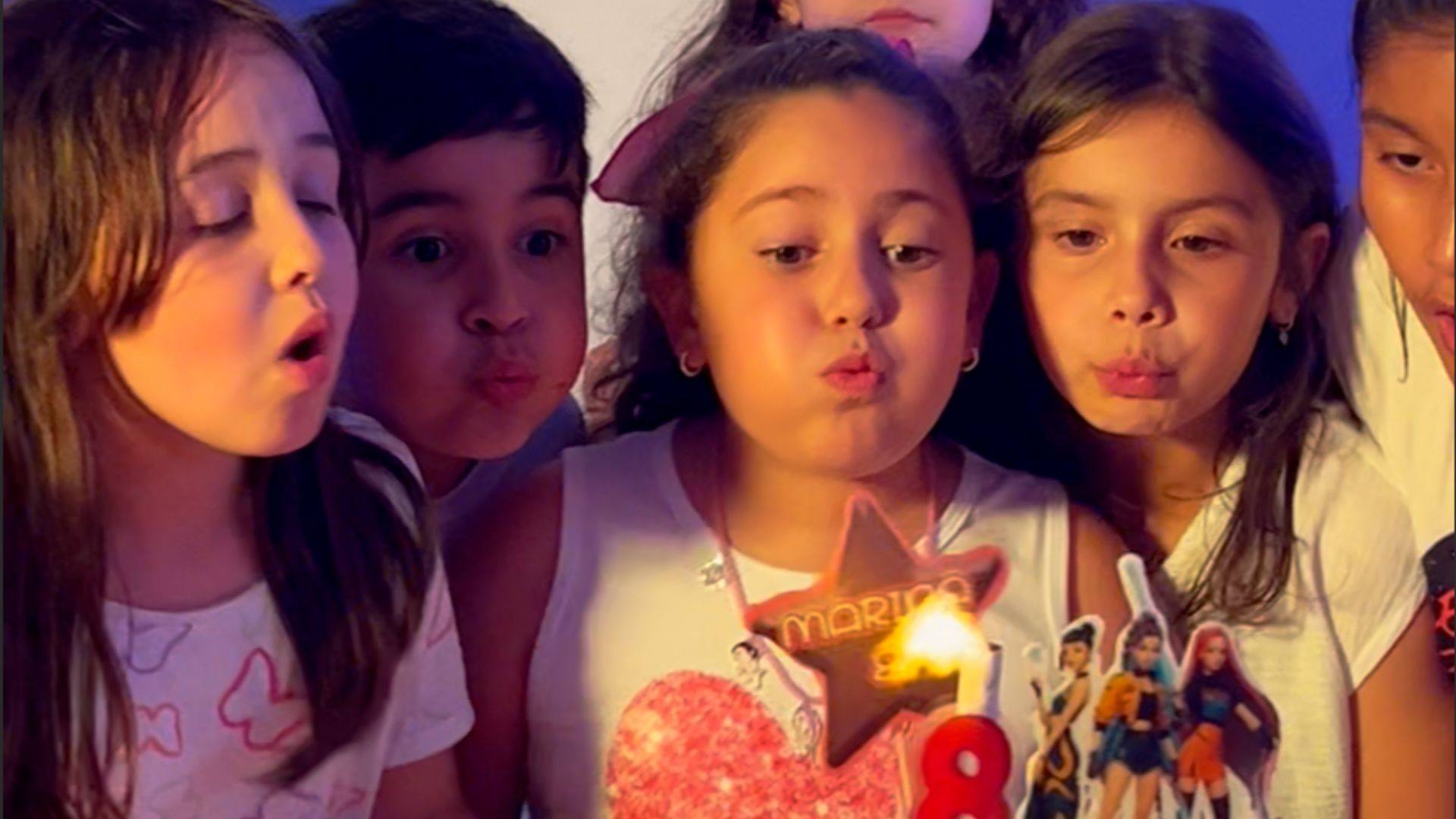 Niñas soplando las velas de una tarta de cumpleaños