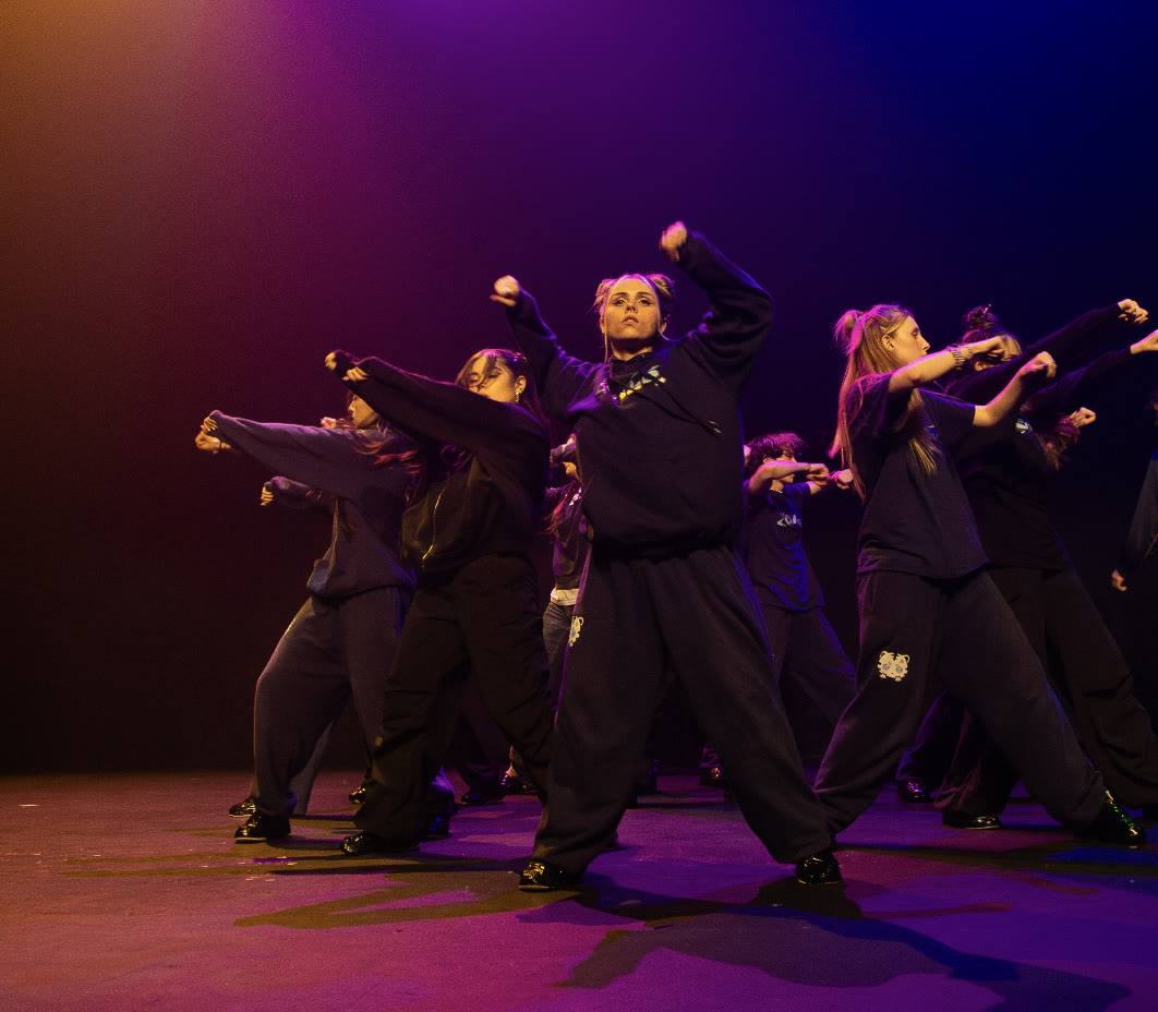 KIBE bailando en el escenario con luz morada